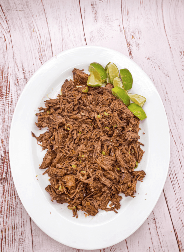 This Instant Pot Ropa Vieja is made with beef round bottom, bell peppers, onions, white wine, broth, tomato sauce, olives and cilantro.