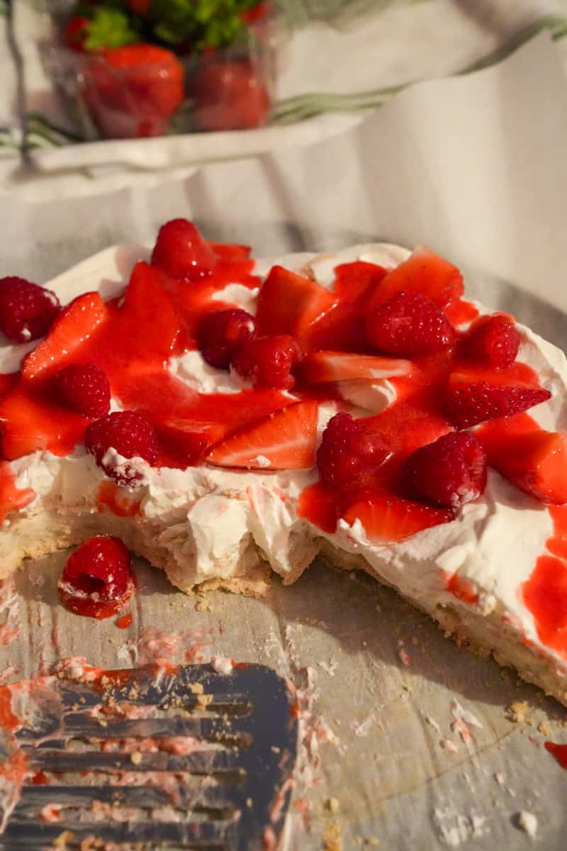 To assemble, spread half of the whipping cream onto one of the meringues. Top with some of the strawberries. The sugar makes the strawberries extract water. Place the second meringue on top of the meringue with the whipping cream. Add the rest of the whipping cream on top of the meringue and top with the rest of the strawberries. Enjoy this Strawberry Pavlova Recipe. 