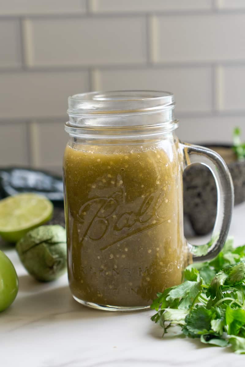 This Tomatillo Poblano sauce is made by boiling serrano pepper, poblano peppers, tomatillos, garlic, red onion, and blending with cilantro and lime.