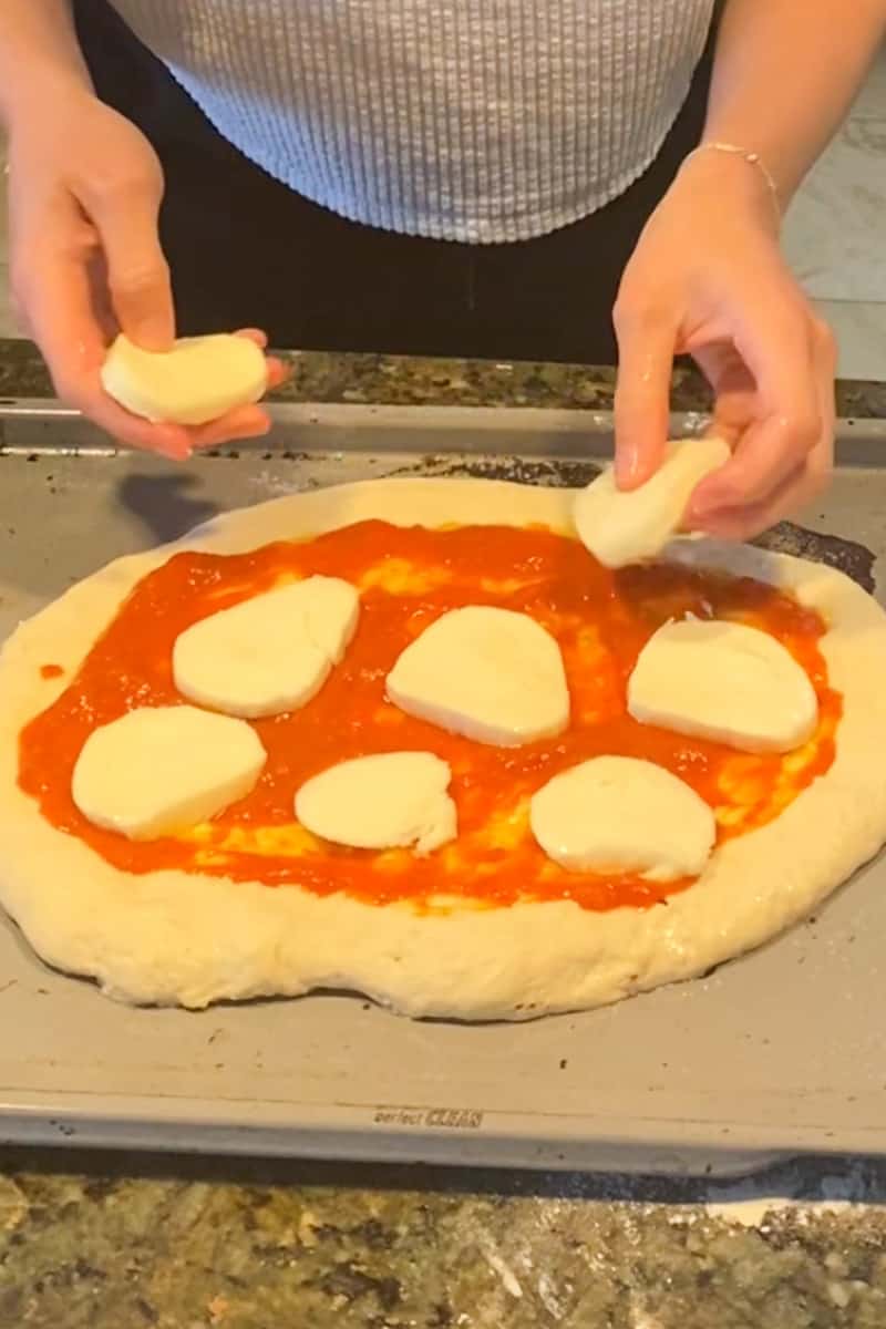 Sprinkle the shredded or fresh mozzarella cheese over the sauce, covering the entire pizza. Arrange the sliced pepperoni, jalapeño slices, and halved cherry tomatoes on top of the cheese. You can adjust the amount of jalapeños based on your desired level of spiciness. Season the pizza with salt and pepper according to your taste.