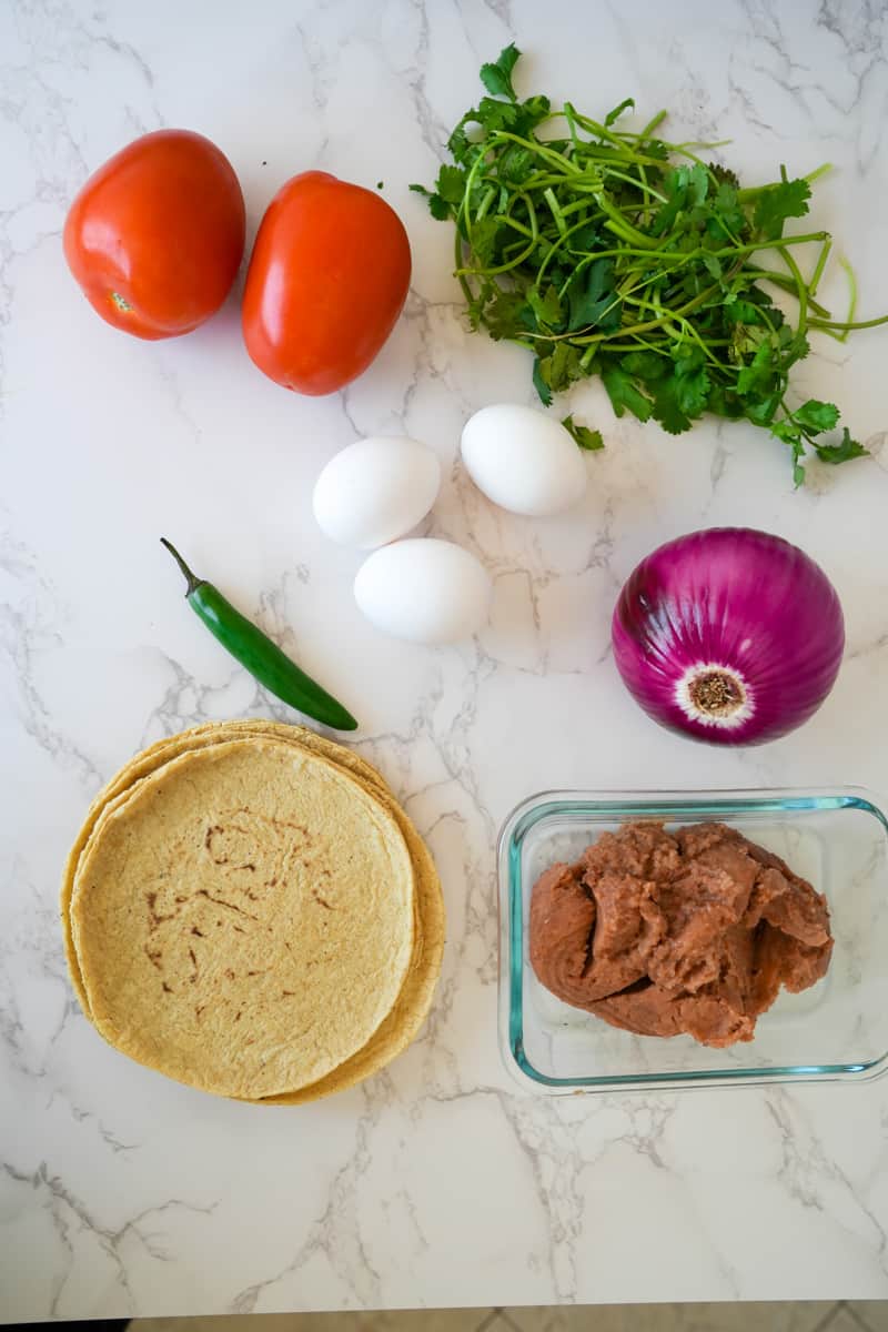 Esta Huevos Rancheros Mexicanos Receta se prepara escalfando huevos en una salsa casera y cubriendo una tortilla frita y frijoles.