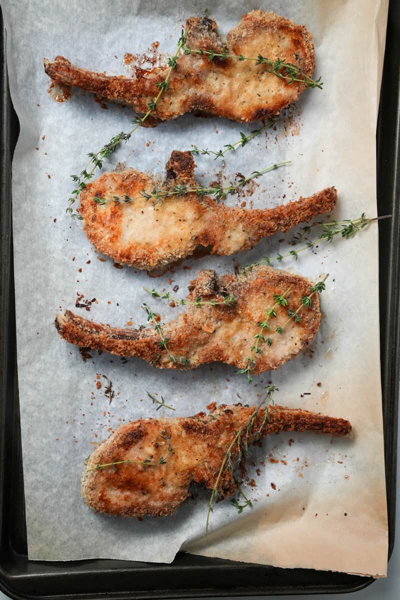 This Oven Baked Pork Chops Recipe is made with pork chops, flour, eggs, breadcrumbs, thyme leaves, and Worcestershire sauce.