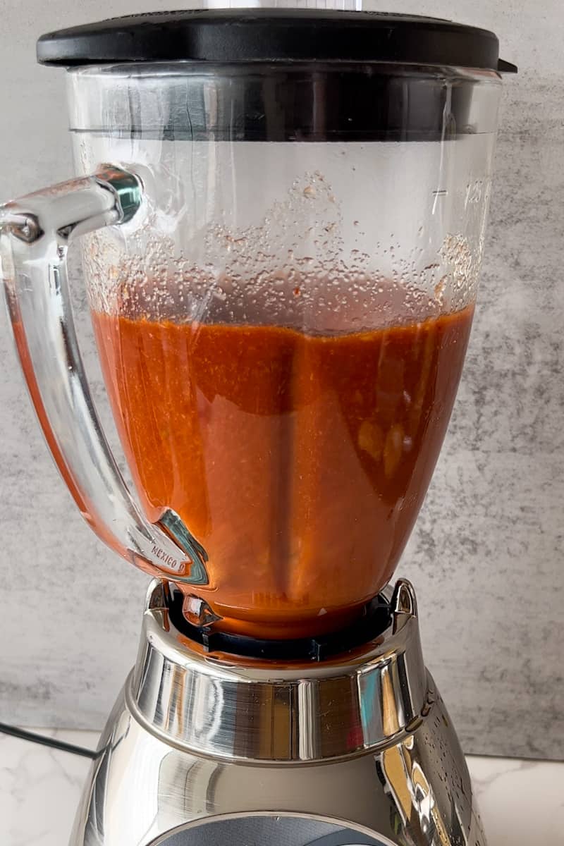 Add the cumin, oregano, and salt to the blender, and puree until smooth, adding more of that chili water as needed to achieve your desired consistency.