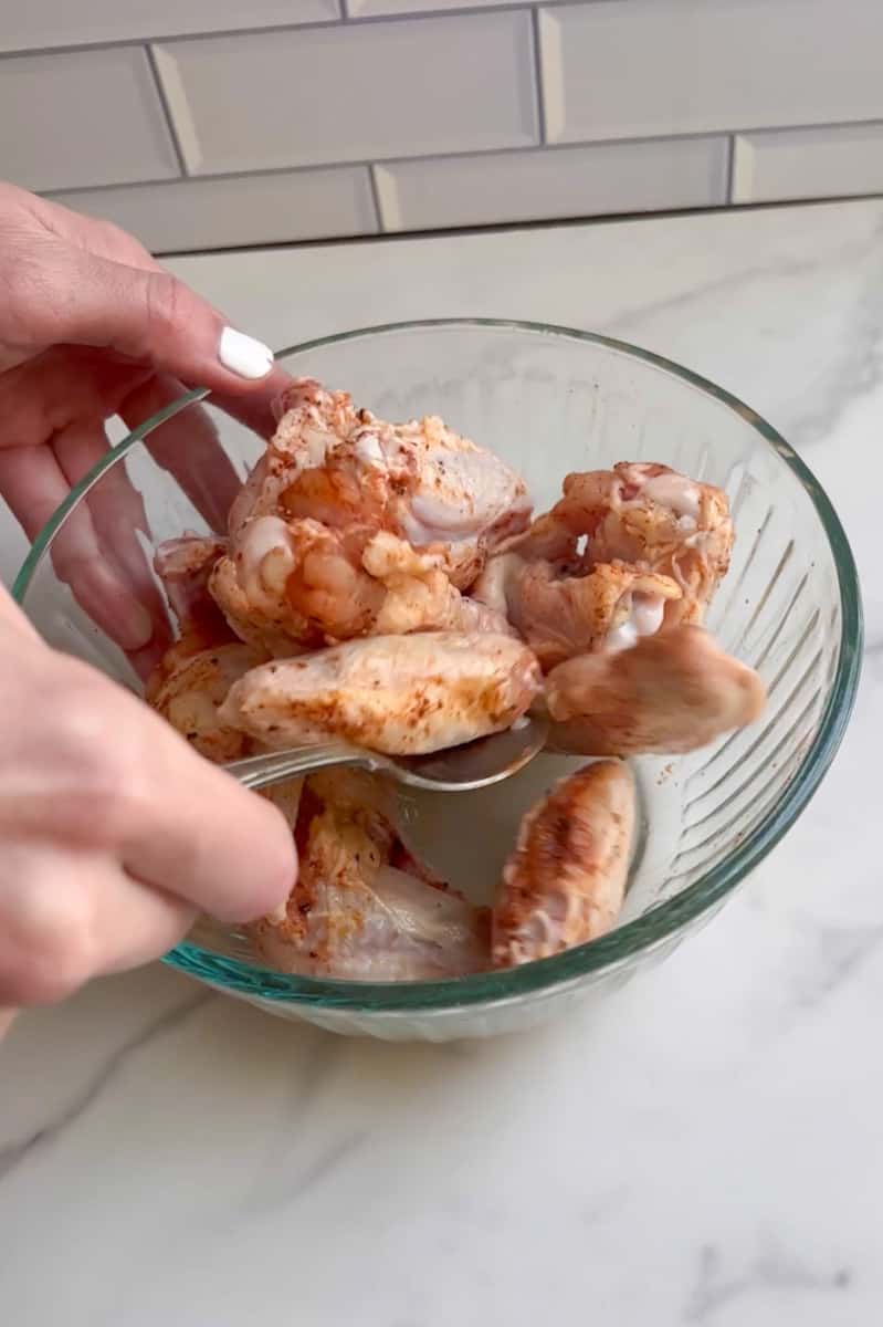 Pat the chicken dry with paper towels. Place the chicken wings in a large bowl and sprinkle the spice mixture over them. Toss the wings to ensure that they are coated evenly.
