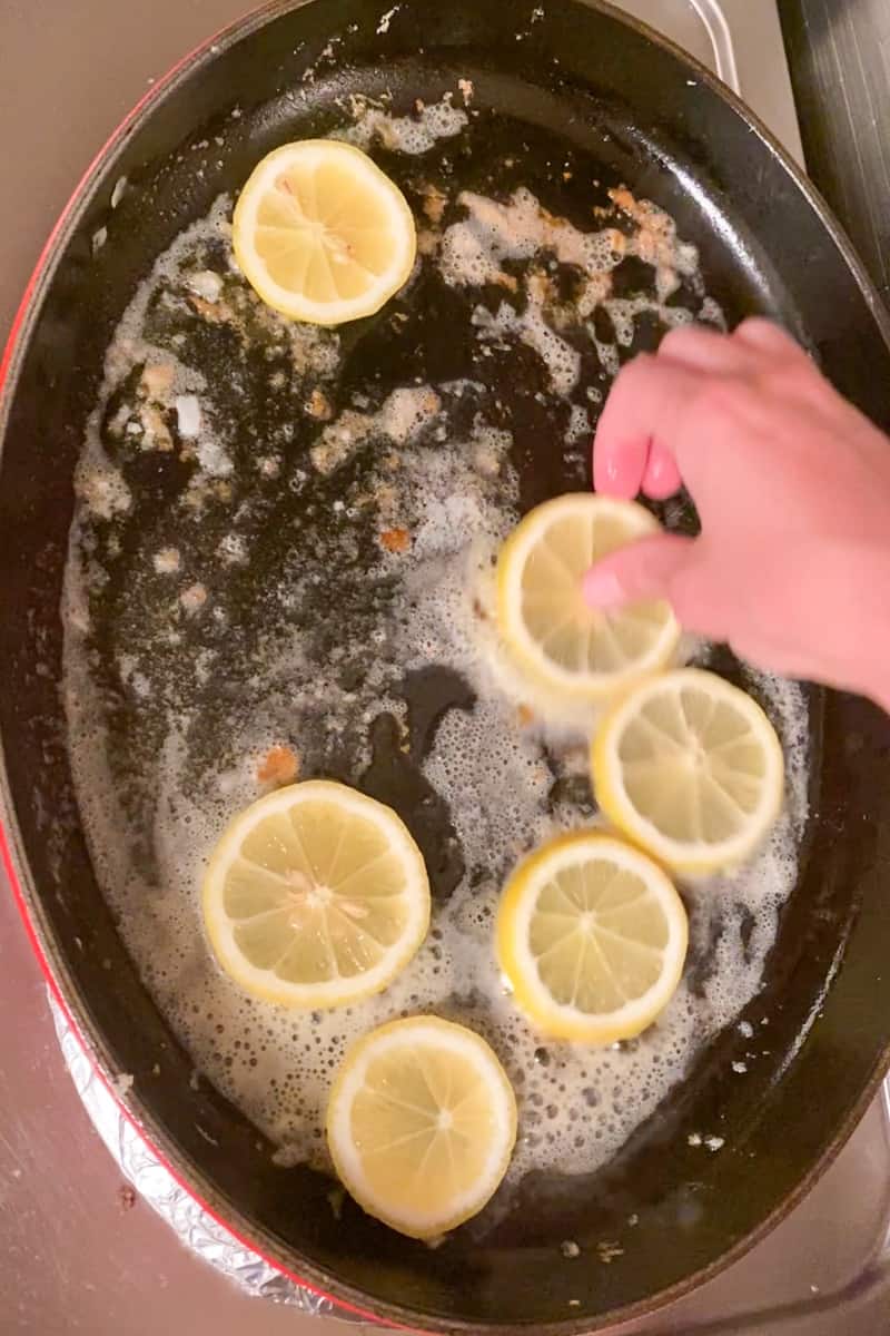 In a large skillet, add the butter and wait until it melts. Place lemon slices on the pan, 1 minute on each side until the lemon caramelizes. With tongs, remove the lemon and place on another separate plate. Add garlic and cook until fragrant, for 1 minute.