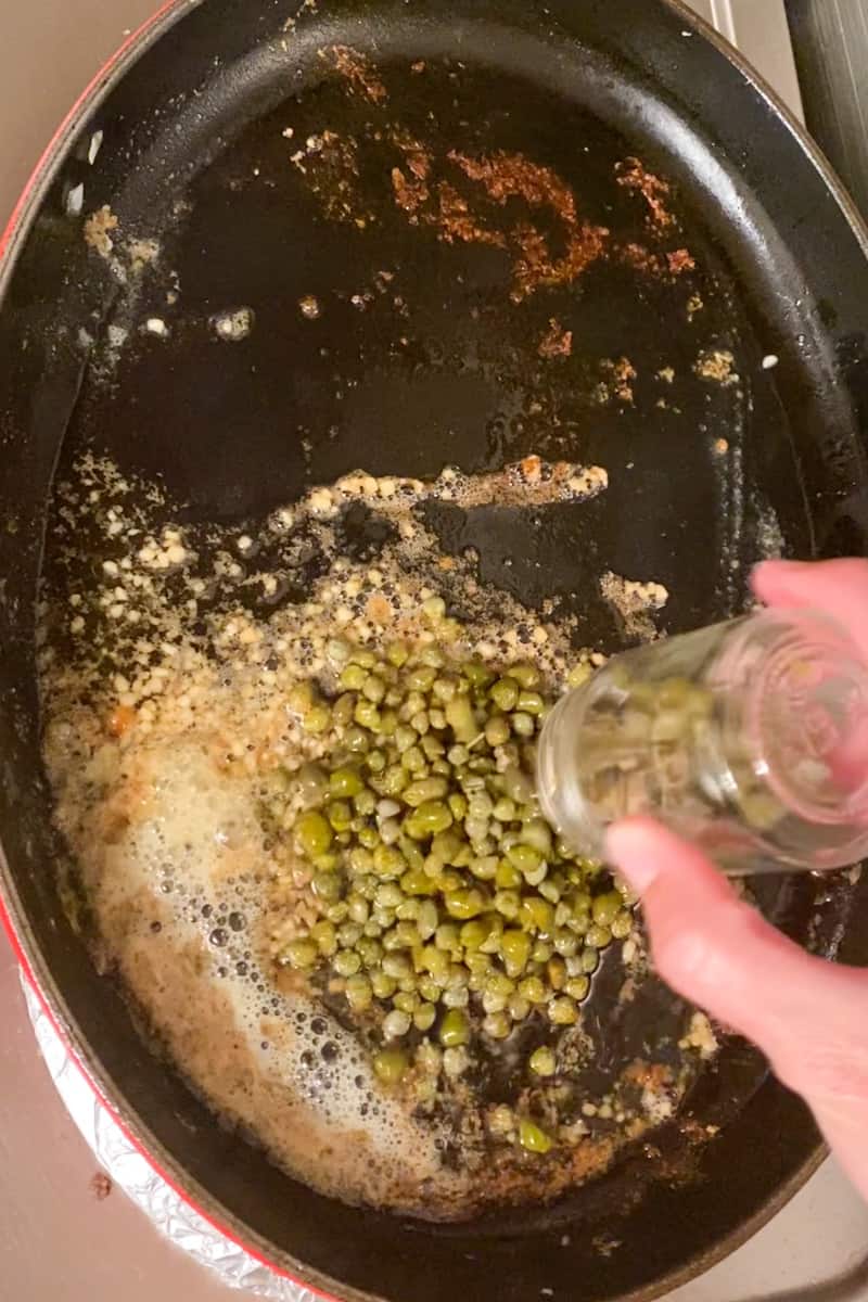 Add the whole bottle of capers with the juice and add the snapper back in the large pan. Cook for another 3 minutes, spooning sauce over fish. 
