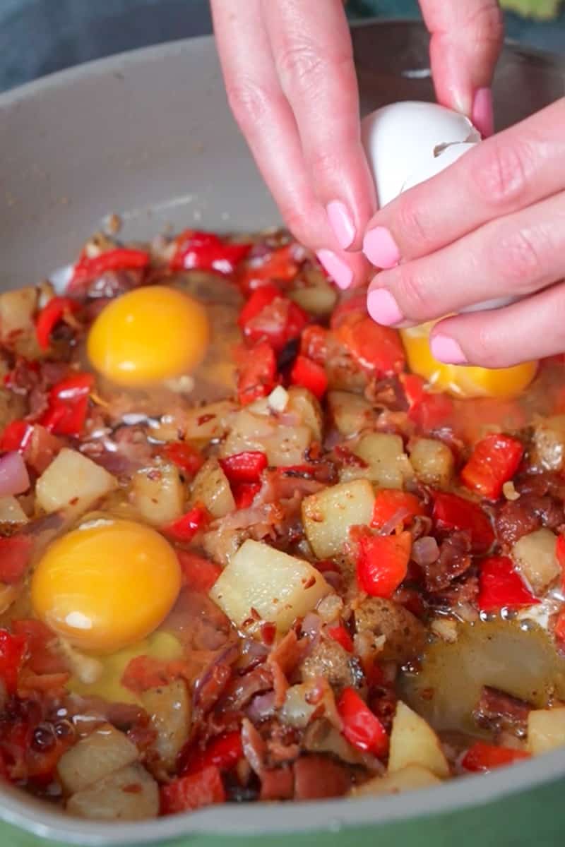Create small wells in the mixture and crack the eggs into these wells. You can cover the skillet with a lid or foil to help the eggs cook faster. Cook the eggs to your desired doneness. If you prefer runny yolks, cook them for a shorter time, and for fully cooked yolks, cook them longer.
