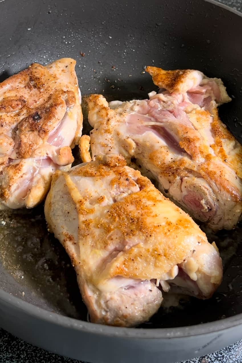 In a large pot or saucepan, heat 2 tablespoons of olive oil over medium-high heat.

Season the chicken thighs with salt and pepper.

Brown the chicken thighs in the hot oil for about 8-9 minutes, flipping once halfway through.

When you flip the chicken, add minced garlic to the pot.