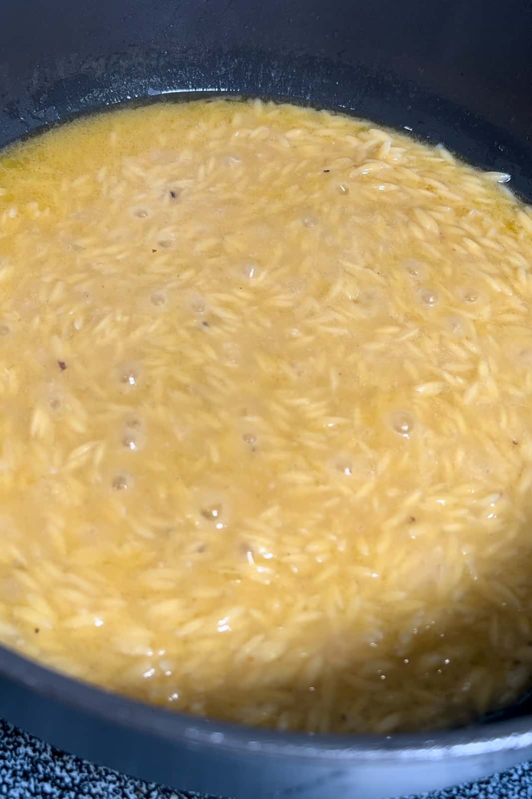 Cook Orzo: Once the chicken is cooked, remove the chicken from the pot and set it on a plate. Pour the remaining chicken drippings into a measuring bowl. Check the volume of the drippings and add store-bought chicken broth to make a total of 2 cups of liquid. Adjust the seasoning if needed. Bring the liquid to a simmer in the pot. Add 1 cup of orzo to the simmering liquid. Cook the orzo uncovered on medium heat for 8-12 minutes or as per the instructions on the orzo package. Stir occasionally until the orzo is soft and the liquid has evaporated.