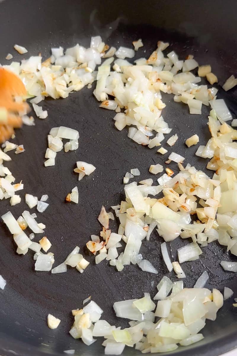 En una cacerola grande a fuego medio-alto, agregue la cebolla y saltee hasta que esté suave, aproximadamente 5 minutos. Agregue el ajo y los camarones en una sola capa y cocine hasta que esten rosados, aproximadamente 1 minuto. 