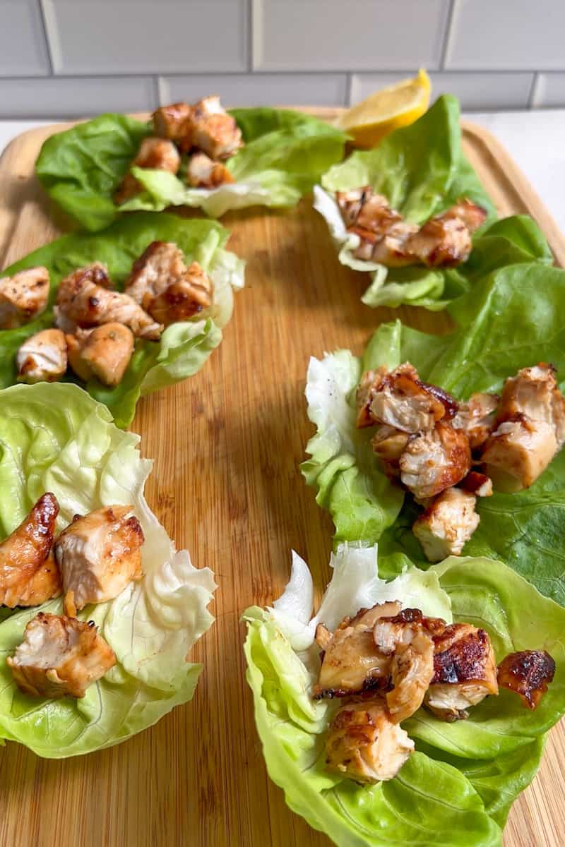 Cubra el pollo en cada lechuga de mantequilla. Adorne con las zanahorias, las castañas de agua, los cacahuates y el cilantro. 