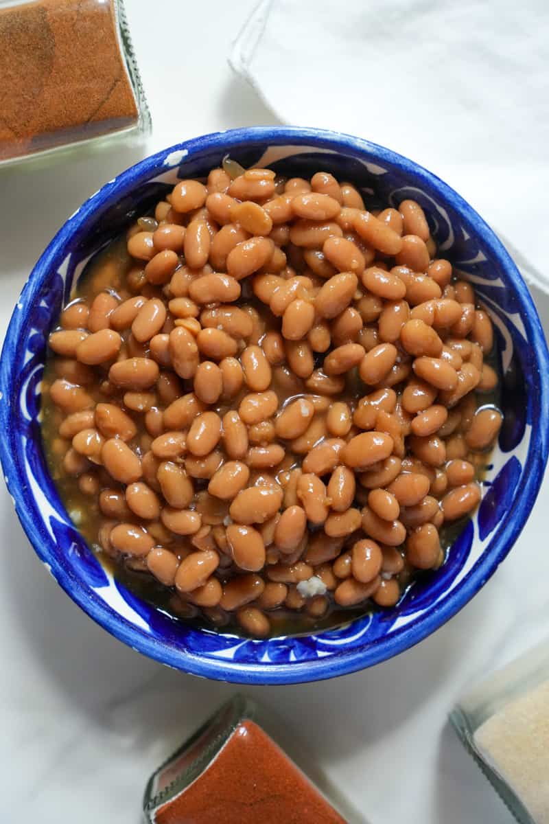 This Instant Pot Baked Beans Recipe is made with dried pinto beans, onion, vinegar, sugar and tomato puree and cooked in the Instant Pot.