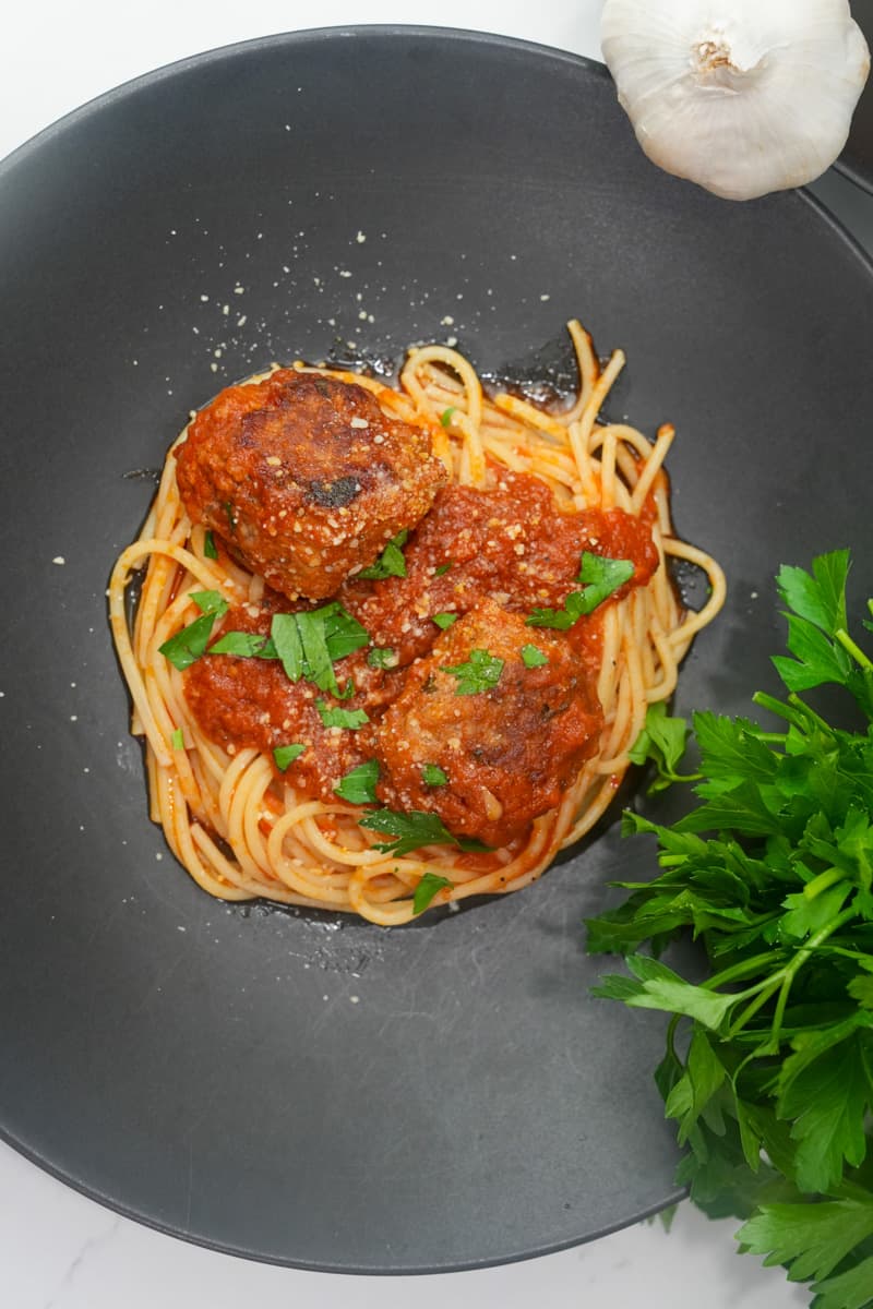 Cook the Spaghetti: In a large pot of salted boiling water, cook the spaghetti according to the package instructions until al dente. Drain the spaghetti and set it aside. Assemble the Dish: Serve the meatballs and sauce over the cooked spaghetti. Garnish with fresh parsley and additional grated Parmesan cheese. Enjoy this Homemade Spaghetti and Meatballs Recipe.