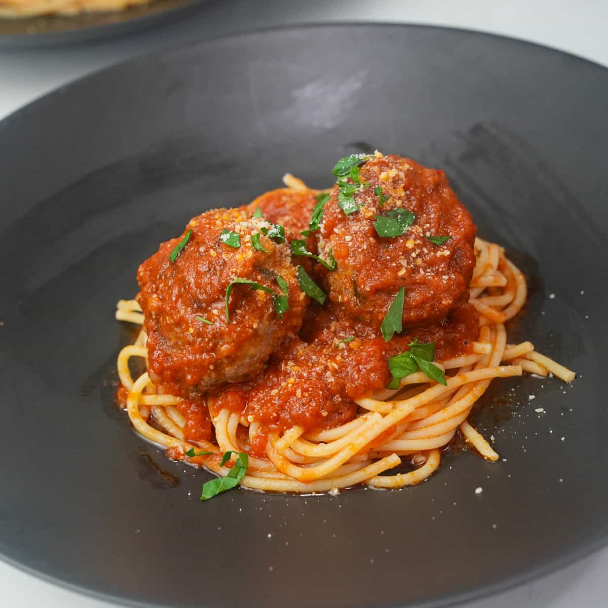 Delight in a culinary classic with our homemade spaghetti and meatballs recipe: perfectly cooked pasta smothered in rich marinara sauce and adorned with succulent, hand-rolled meatballs.