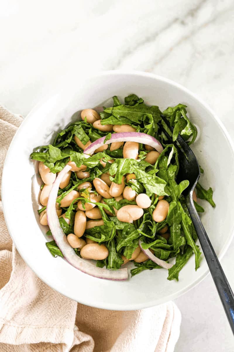 This Lemony White Bean Arugula Salad (Vegan) is made with arugula, cannellini beans, red onion, lemons, olive oil, maple syrup and tossed.