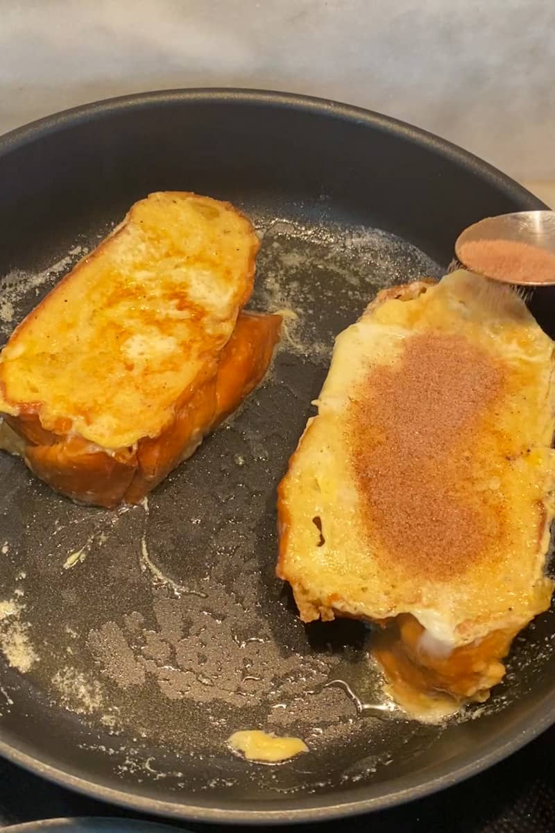 In a bowl, add the sugar and cinnamon and combine. Heat up a large pan over medium heat. Add about 1 tablespoon butter and wait for it to melt. Cook the toast until light golden, about 2 minutes, then flip to the other side for about 4-5 minutes.