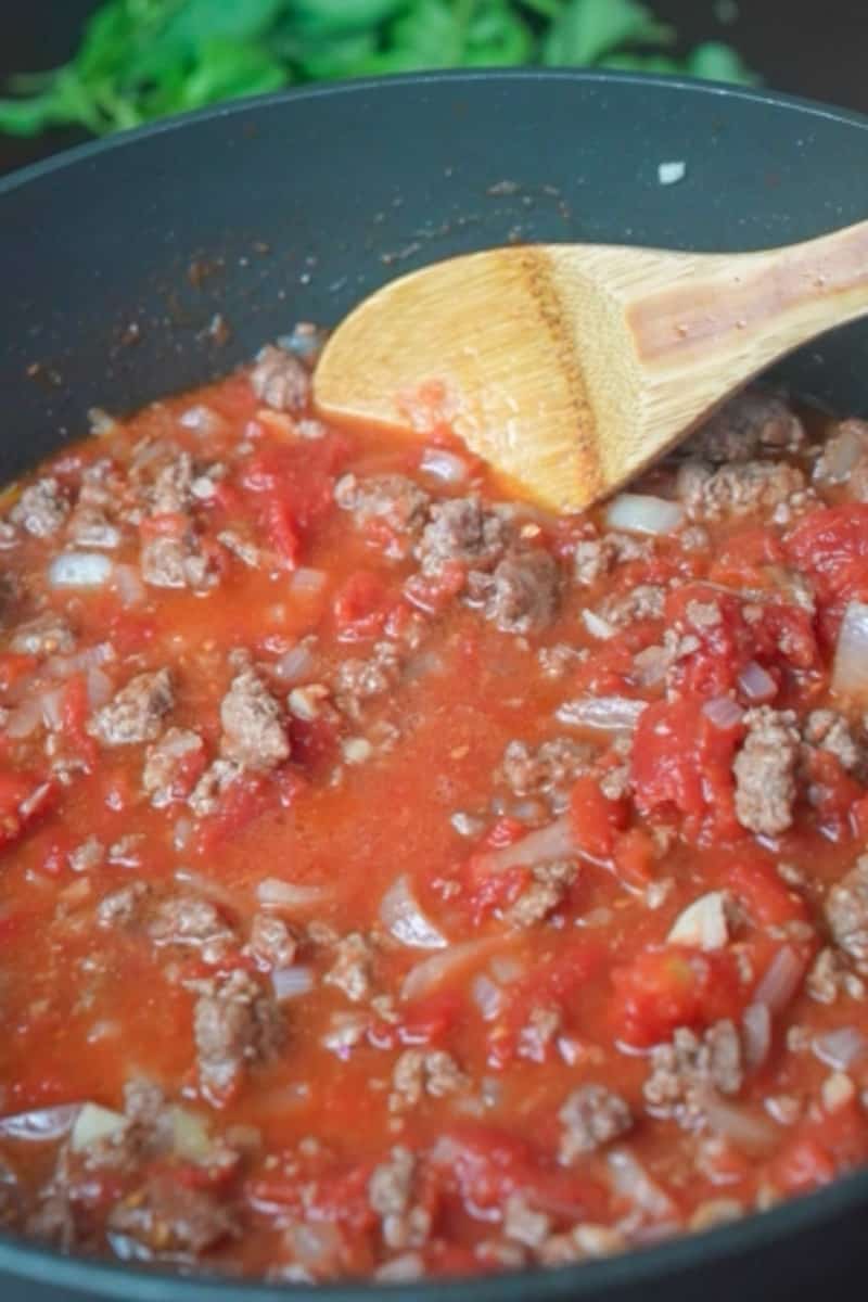 Break it up with a spatula and cook until it's browned and no longer pink. Stir in the tomato paste, salt, and pepper to taste. Cook for 2-3 minutes to enhance the flavors. Pour in the crushed tomatoes and bay leaves and let the sauce simmer for at least 30 minutes, stirring occasionally.