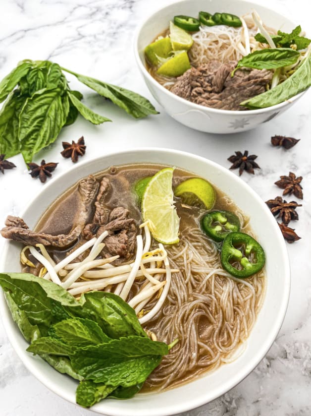 This is an easy Vietnamese Pho Tai recipe that is made with thin-cut sirloin, rice noodles and garnished with lime, cilantro, and chilies.