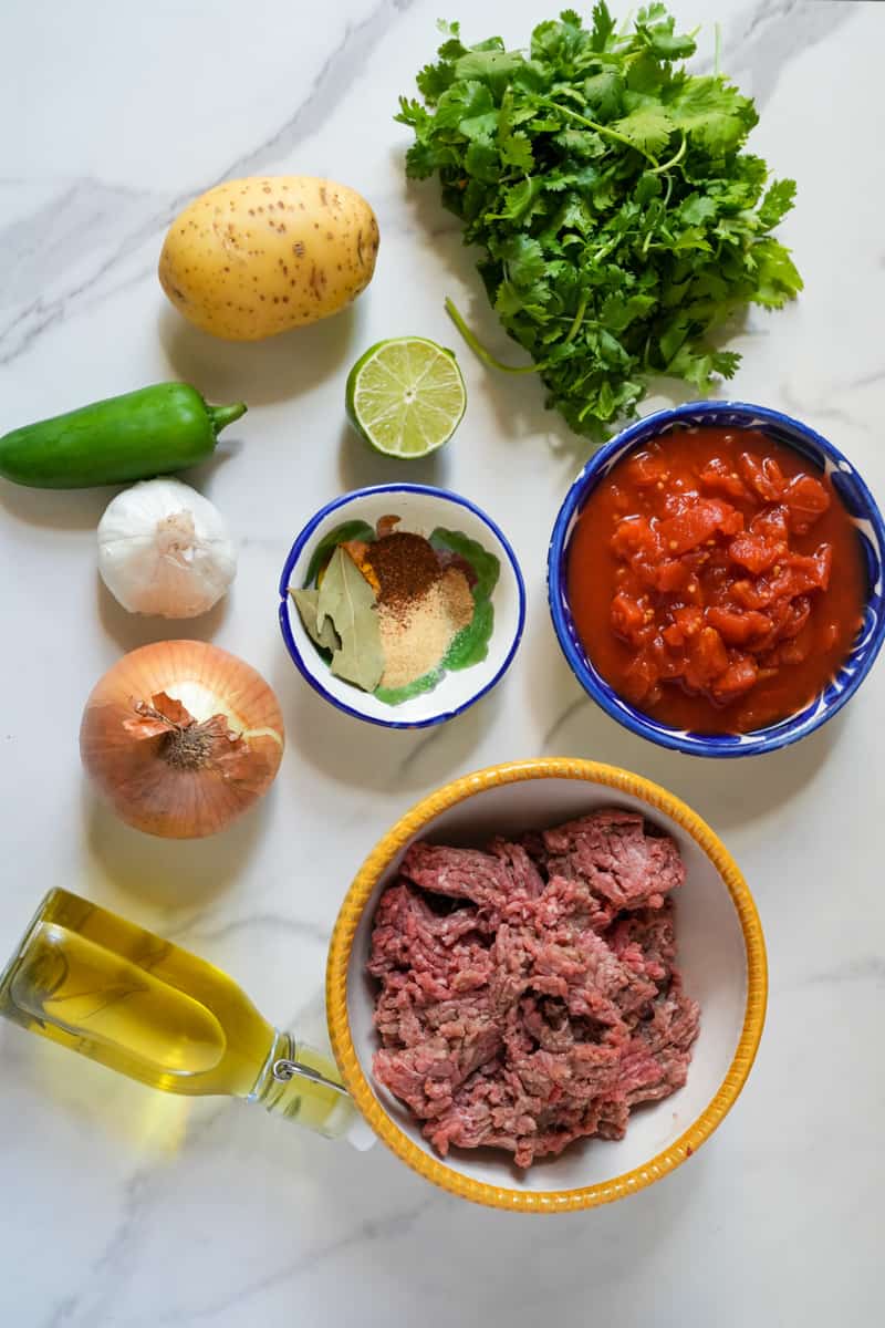 This Picadillo Recipe is made with ground beef, onion, jalapeños, chili powder, cumin, and garnished with cilantro and limes.