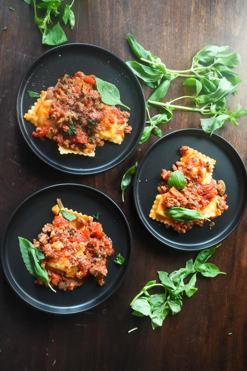 Serve: To serve, place a portion of cooked cheese ravioli on each plate. Spoon the Bolognese sauce generously over the ravioli. Garnish with fresh basil leaves.