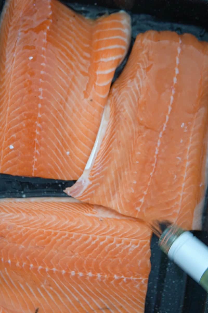 Put the salmon in a large wide container or baking dish and add enough wine to cover it. Soak for 2 to 4 hours.
