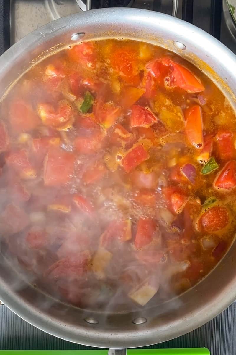 Add the tomatoes and cook altogether, for another 6 minutes, until the tomatoes begin to soften up. Add a cup of water and chicken bouillon and bring to a boil.