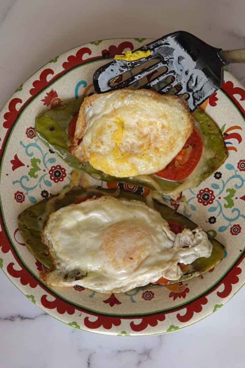 After 2 minutes, sprinkle cheese on each nopal until it starts to melt. Place 2 slices of tomato on each nopal and remove from heat, and cover for 5 minutes until the cheese melts. 