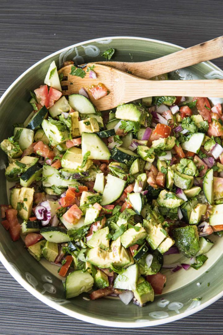 This Avocado Tomato Salad is made with tomatoes, cucumbers, avocados, onions, olive oil, lime juice, cilantro and salt.