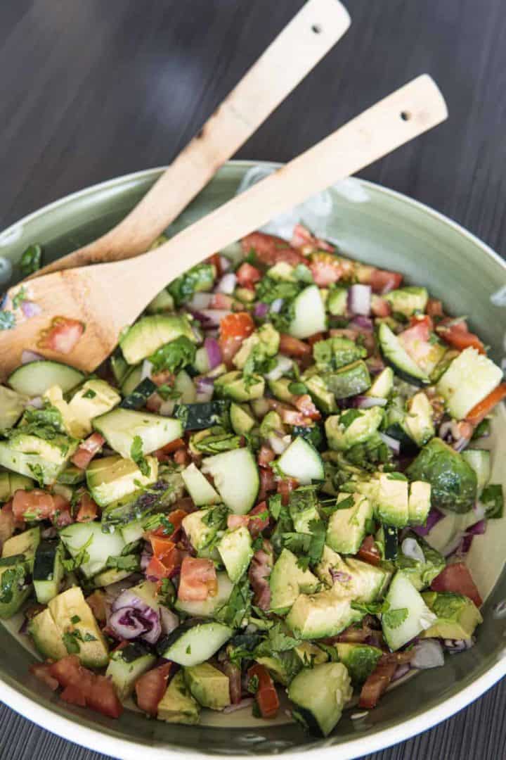 This Avocado Tomato Salad is made with tomatoes, cucumbers, avocados, onions, olive oil, lime juice, cilantro and salt.