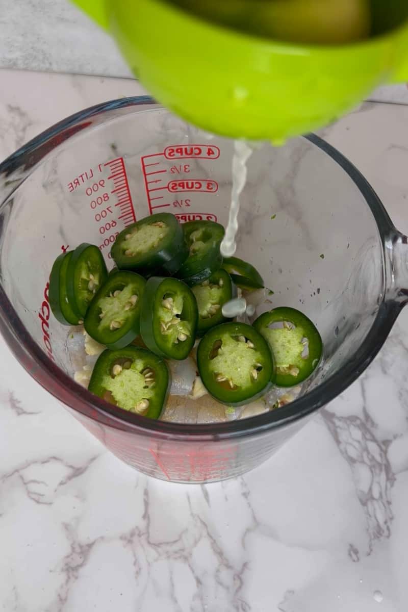 In a mixing bowl, add the shrimp, olive oil, garlic, honey, jalapeño, lime juice, lime zest, garlic powder, salt and mix. Marinate for 15 minutes. 