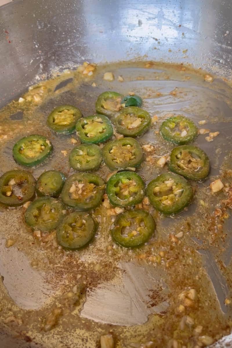 Remove the shrimp with tongs and leave the sliced jalapeño. The longer it cooks, the less spicy the jalapeño is. Turn the heat off and stir in the honey. With a wooden spoon, blend the butter and honey together. Add the shrimp back in to stir everything together.
