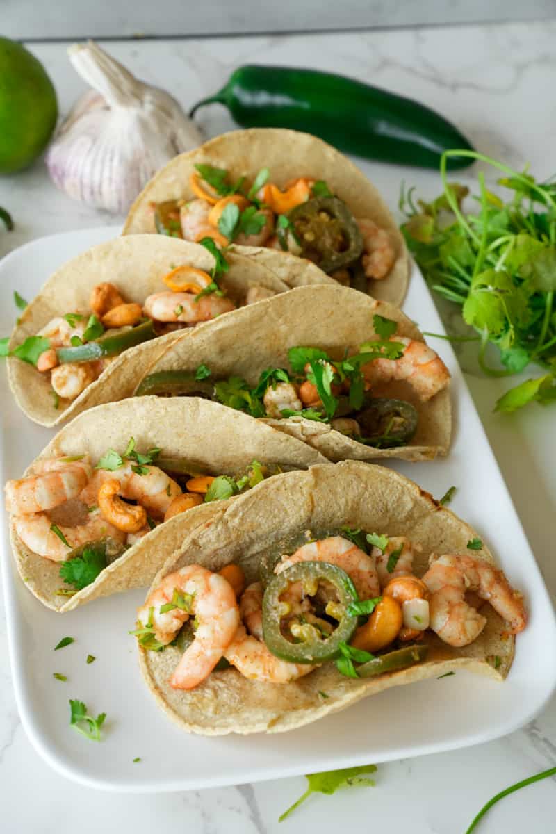 This Honey Lime Shrimp Tacos dish is made with shrimp, olive oil, garlic, jalapeños, limes, butter, and served on a warm tortilla.