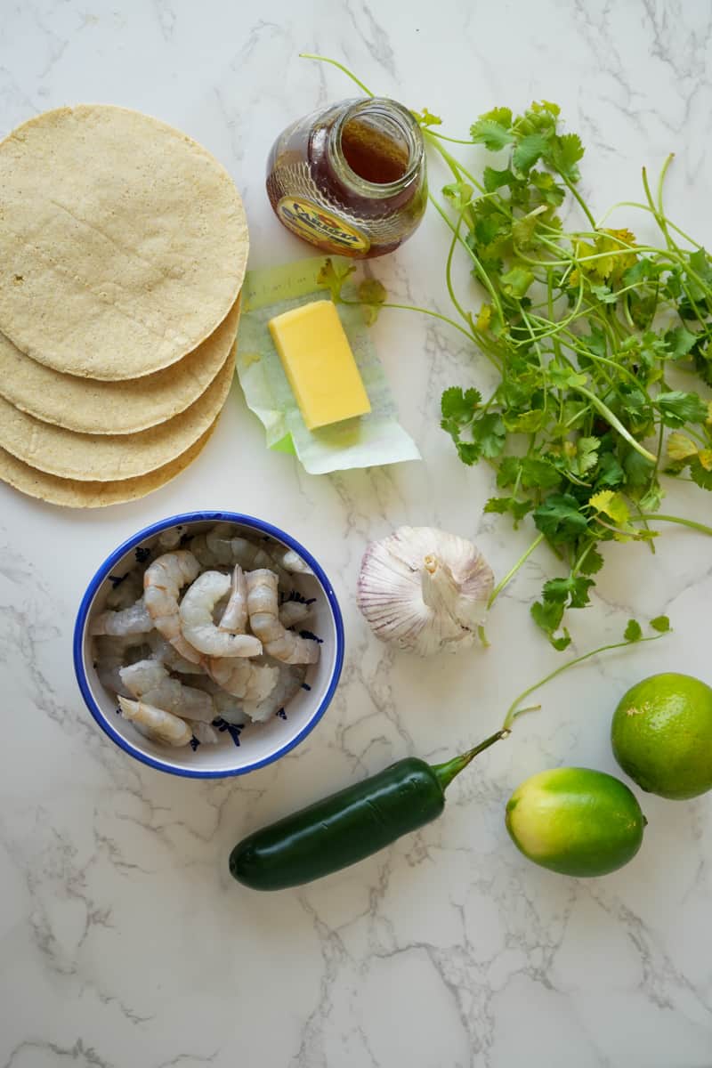 This Honey Lime Shrimp Tacos dish is made with shrimp, olive oil, garlic, jalapeños, limes, butter, and served on a warm tortilla.