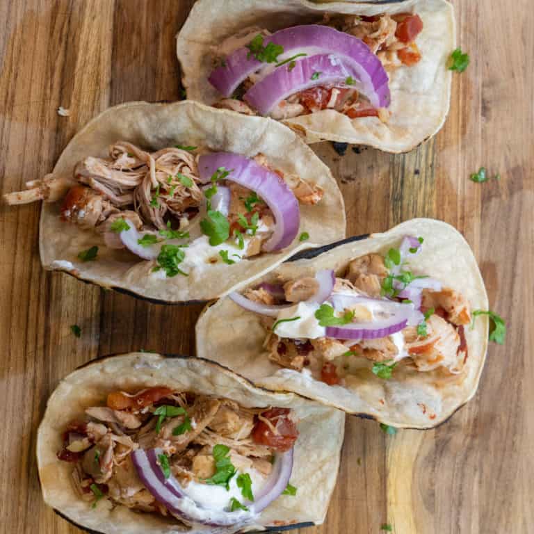 This Chicken Tinga Instant Pot are made with chicken breast, garlic, onion, chipotle peppers, tomatoes, and tortillas.
