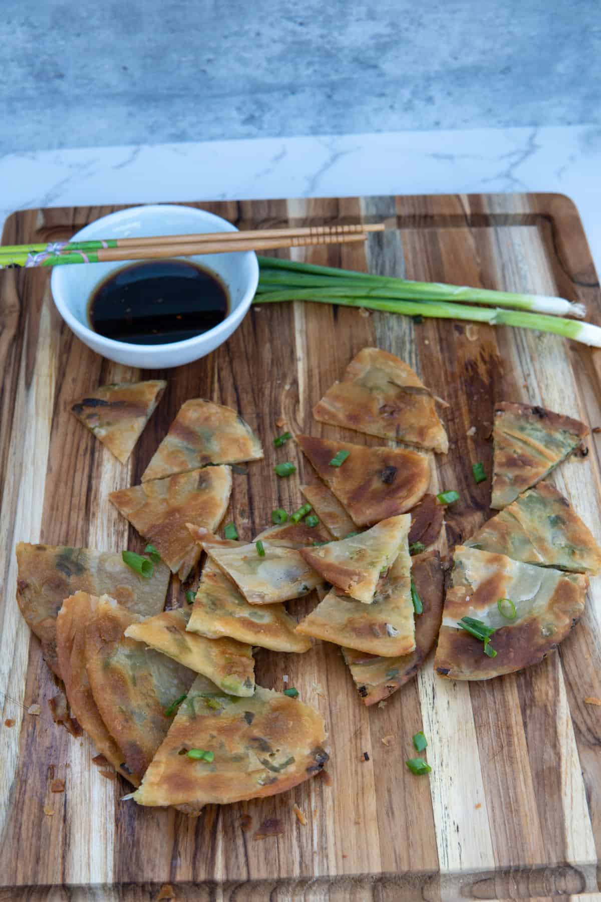 These Scallion Pancakes Recipe are made with flour, salt, scallions, vegetable oil, and dipped in a soy sauce, vinegar, and maple syrup.