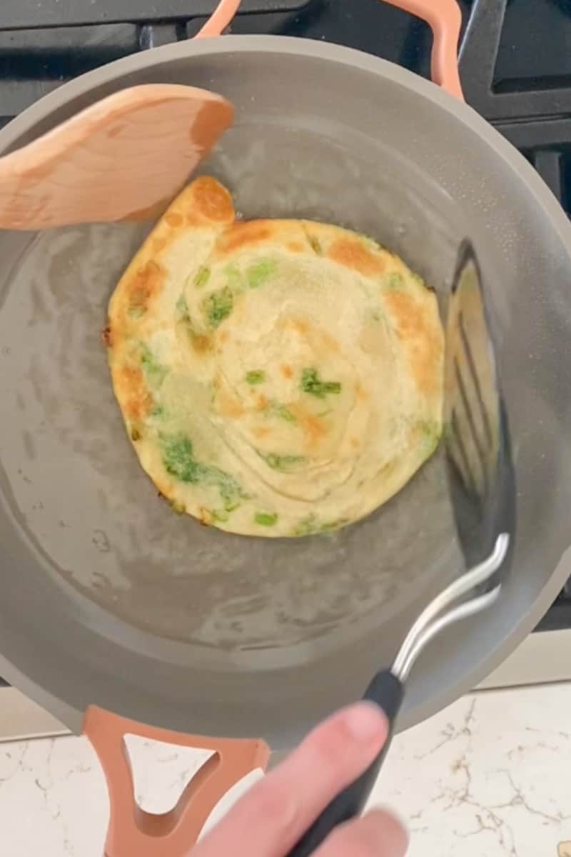 Cook the pancakes. Heat up 3 tablespoons vegetable oil in a large skillet over medium low heat and wait for it to shimmer. Working with one at a time, cook the pancake, about 4 minutes on each side, until golden brown. Transfer pancakes to a wire rack to cool before cutting into wedges.