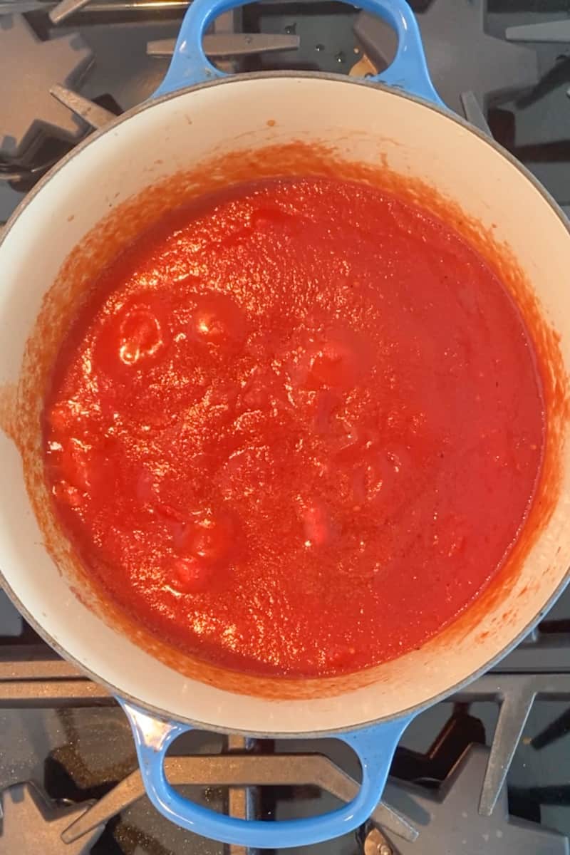 Pour in the tomato puree, salt, pepper, and red pepper flakes and let it simmer for 15 minutes, stirring occasionally.