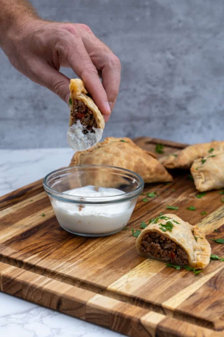 These Spicy Beef Empanadas are made with red onion, garlic, jalapeños, potatoes, ground beef, diced tomatoes, chili powder, cumin, limes, cilantro and bay leaves.