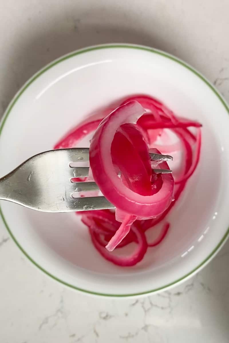 This Pickled Red Onions Recipe is made with red onion, water, vinegar, and bay leaves and made in under 5 minutes.