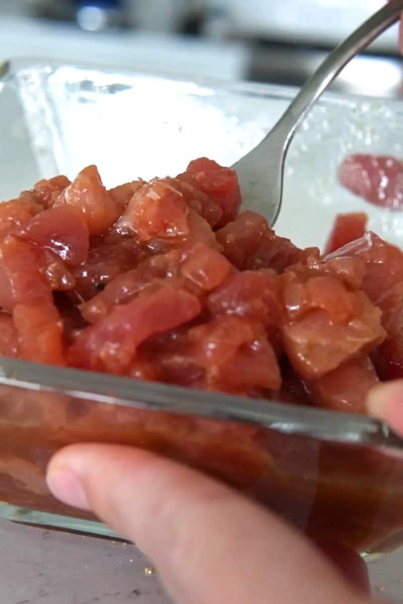 Pour in the tuna into a ramekin and then place the diced avocado and cucumber into it. 