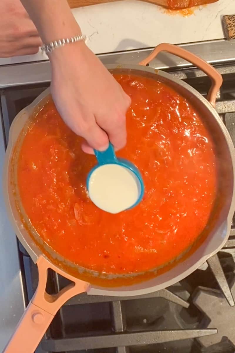 While the sauce is simmering, cook the pasta according to package instructions.  Reserve 1 cup of pasta water. When the sauce seems about ready, add the cream and 3 tablespoons pasta water.