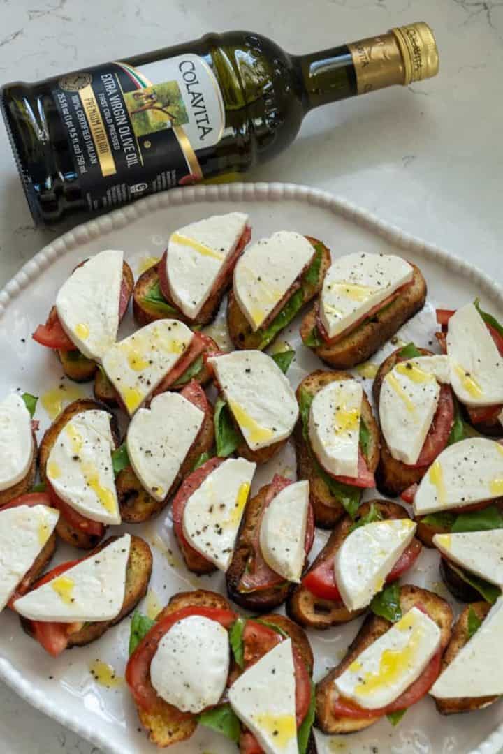 These caprese crostini are made with Italian bread, mozzarella cheese, basil leaves, tomatoes and olive oil as desired. 