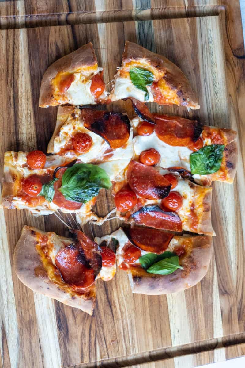 This Pepperoni Pizza Recipe with Marinara Sauce is made with homemade dough, marinara sauce, mozzarella, pepperoni, and cherry tomatoes.