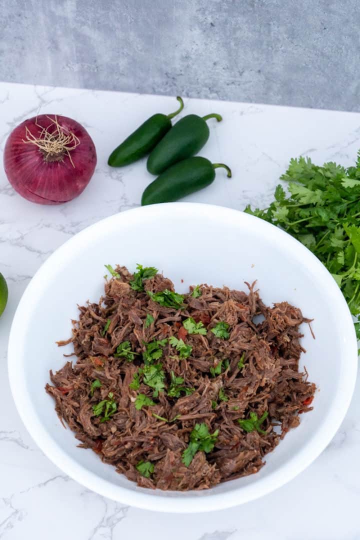 This Authentic Beef Tinga Recipe is made with chuck roast, olive oil, red onion, garlic, jalapeños, chipotle peppers, and tomatoes.
