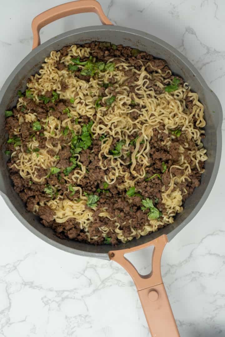 Remove from heat and toss in the cooked noodles. Garnish with cilantro. Enjoy this Ground Beef Ramen. 
