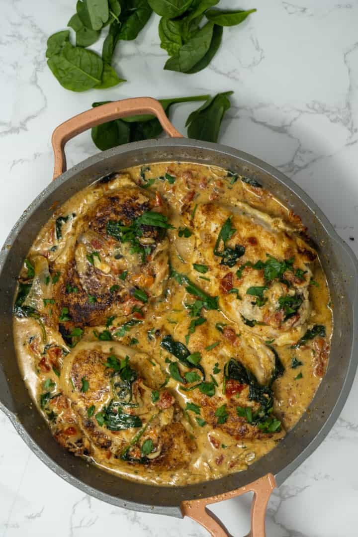 This Creamy Marry Me Chicken with Sun-dried Tomatoes is made with chicken breasts, butter, oregano, garlic, sun-dried Tomatoes, broth, cream, parmesan and spinach.