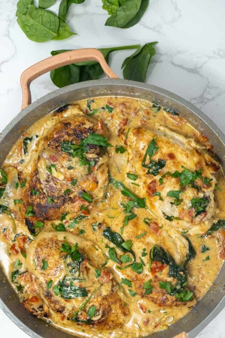 This Creamy Marry Me Chicken with Sun-dried Tomatoes is made with chicken breasts, butter, oregano, garlic, sun-dried Tomatoes, broth, cream, parmesan and spinach.