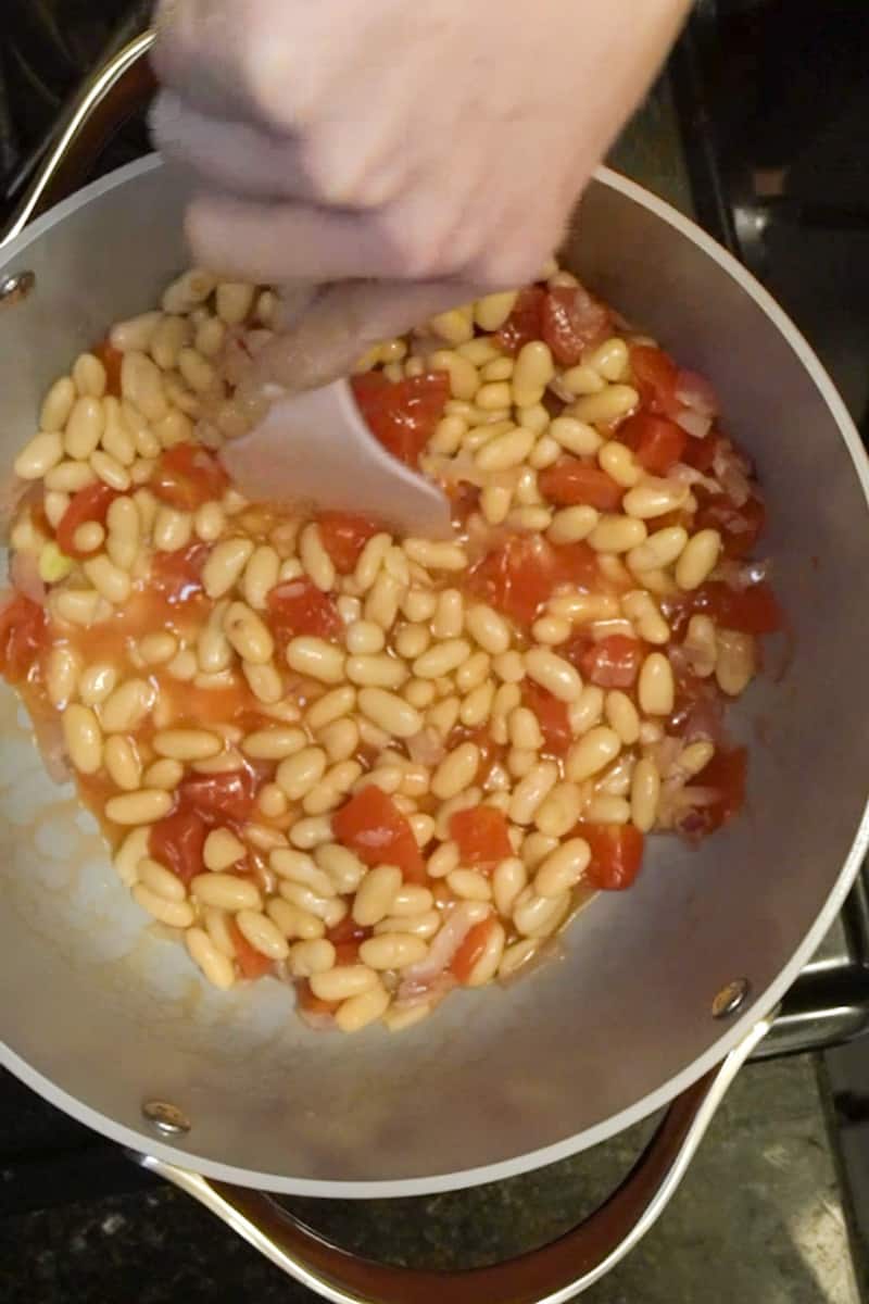 Add both the beans, diced tomatoes, red pepper flakes, salt, pepper. Stir for two minutes then add the chicken broth.