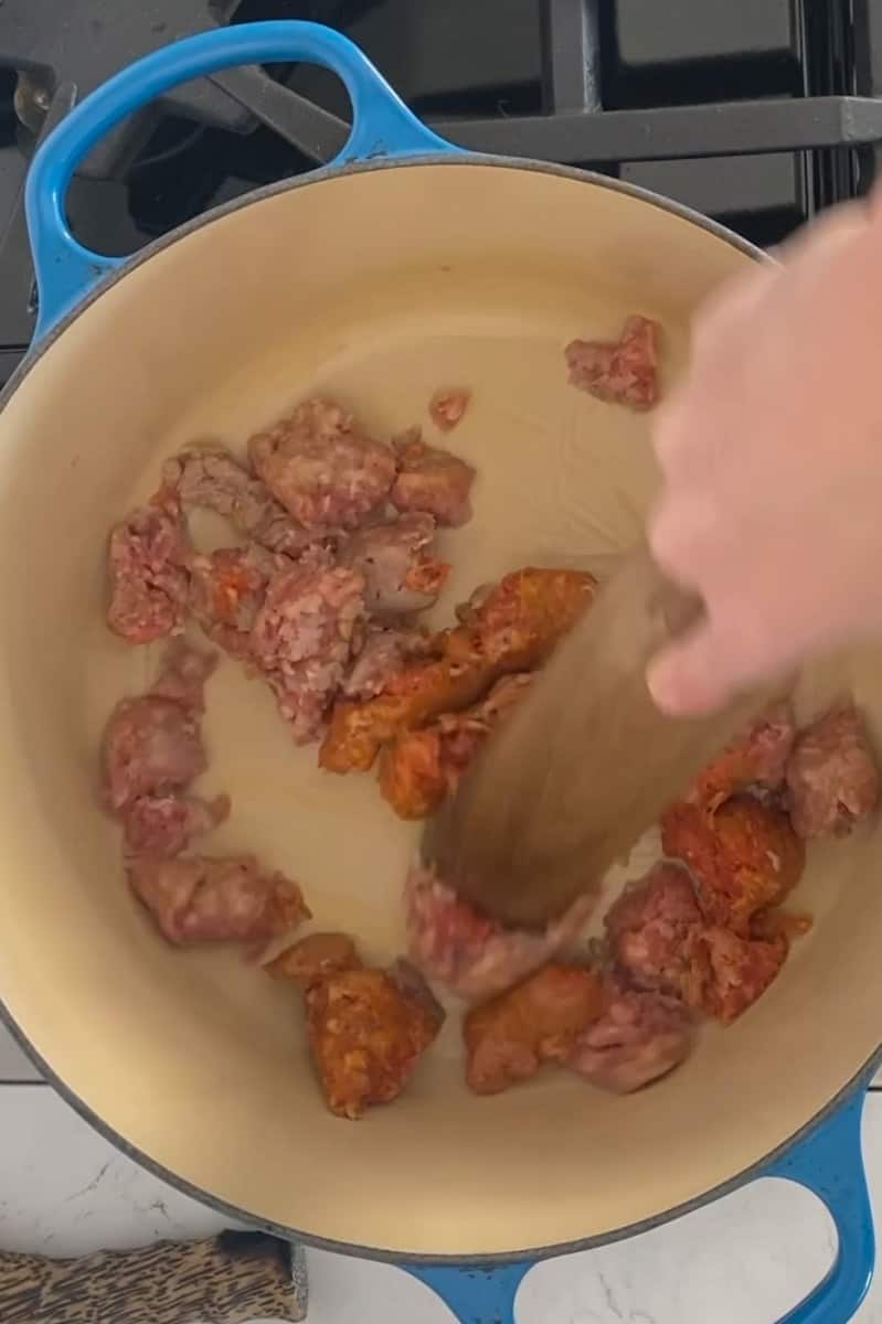 In a large Dutch oven on medium heat, add oil and wait for it to shimmer. Add sausage until brown, about 8 minutes, tossing frequently. Remove and place the sausage on a plate. If needed add more oil, then and add onions until transparent, about 5 minutes.