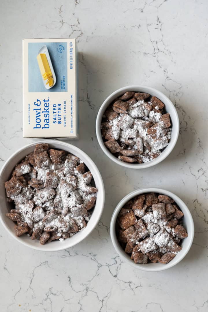 These Cookie Butter Puppy Chow are made with Rice Chex, semisweet chocolate chips, Pillsbury Sugar Cookie Dough, vanilla extract, salted butter, and powdered sugar.